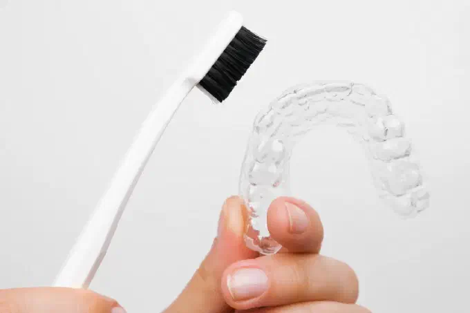 Image of a clear aligner and tootbrush