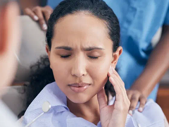 Woman holding her jaw in pain from a toothache